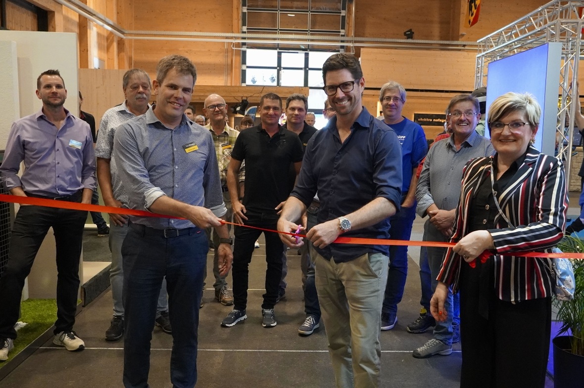 Nationalrat Lars Guggisberg durchschnitt die rote Schnur, flankiert von Tom Witt...