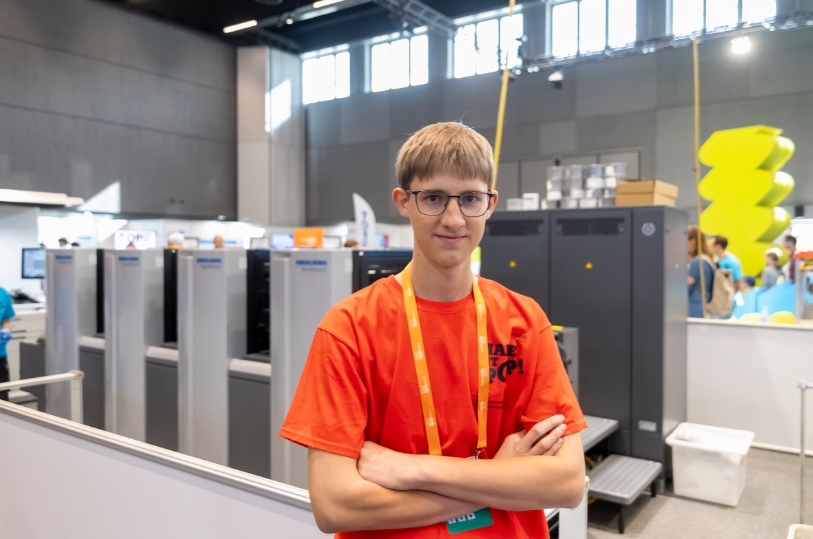 Nico Kopp vor der Offsetdruckmaschine an den SwissSkills in Bern.