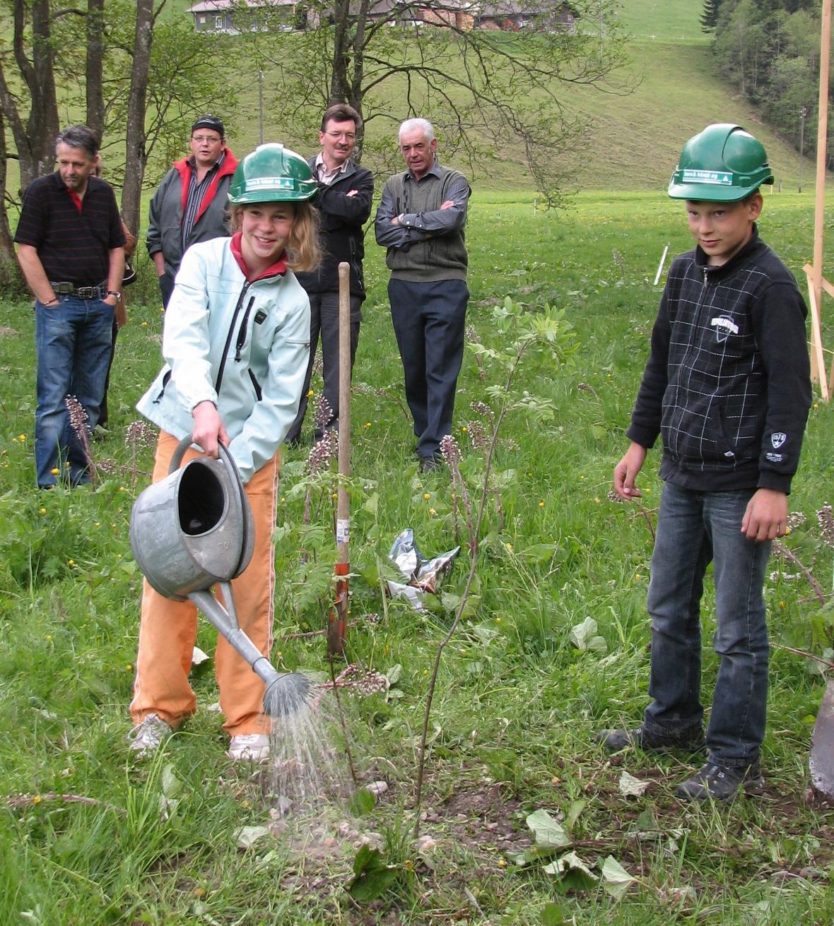 Spatenstich für Wasserspielplatz Patricia Reber, Schülerin aus Schwenden, beim Begiessen der gepflanzten Vogelbeersträucher, im Hintergrund verfolgen Markus Bähler, Martin Wiedmer, Markus Mösching und Peter Knutti, Gemeindepräsident, das Geschehen.