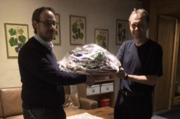 Präsident Stefan Janzi überreicht ein Präsent an Dirigent Marc Mathis.