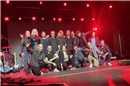 Premiere geglückt. Gruppenbild der Sängerinnen und Sänger, zusammen mit der Band...