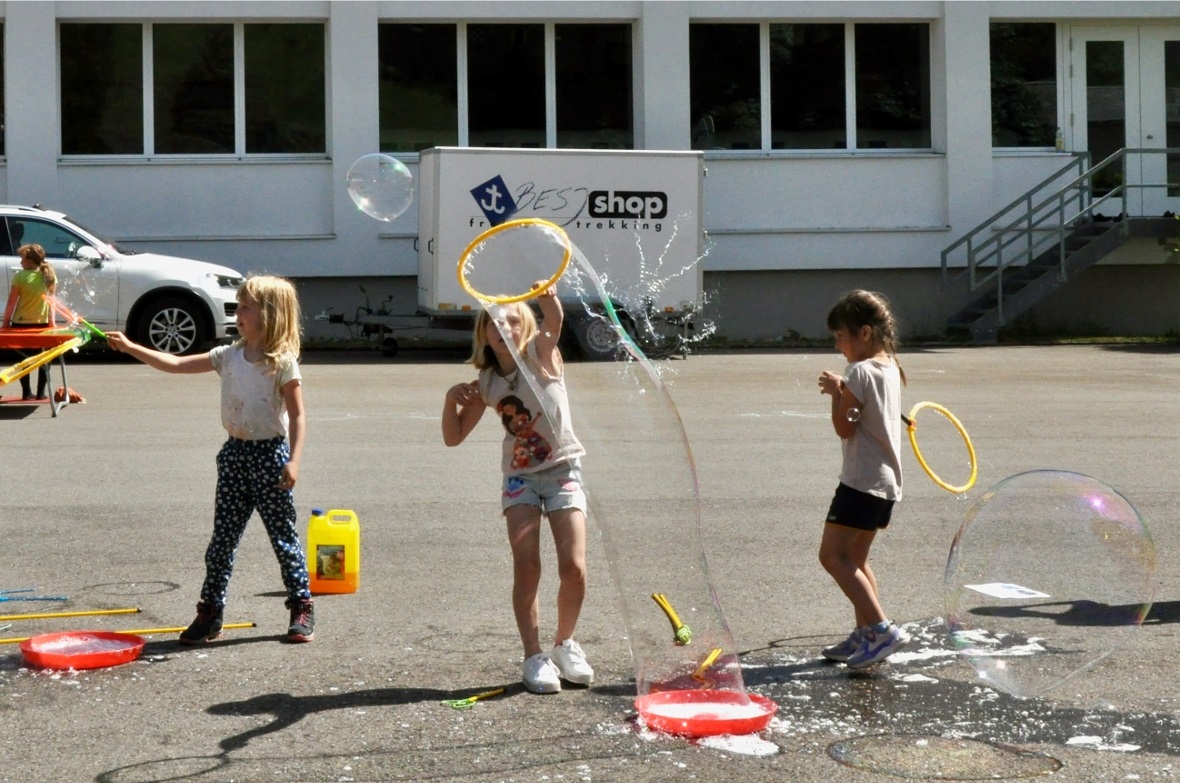 Primarschülerinnen beim Seifenblasen machen.