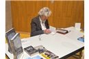 Reinhold Messener beim signieren von Büchern.