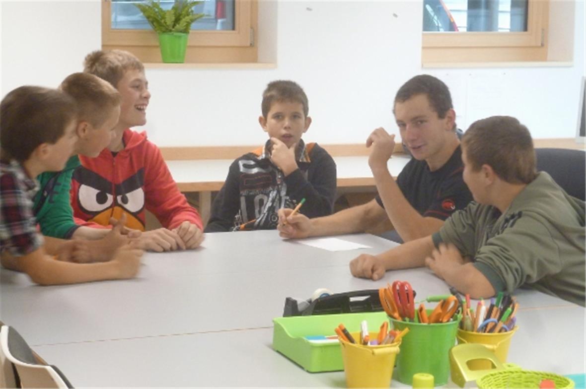 Schüler simulieren Sitzung im neuen Lehrerzimmer.
