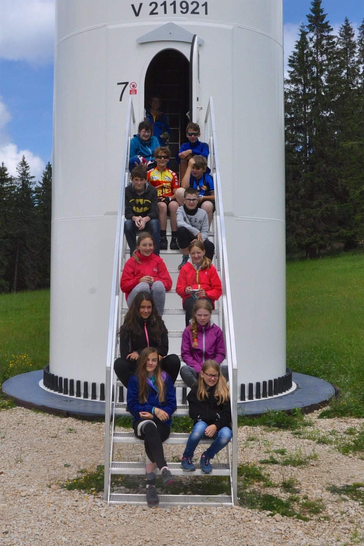 Schülerinnen und Schüler auf der Treppe zur Windkraftanlage.