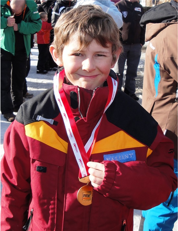 Simon präsentiert stolz die Gold Medaille.