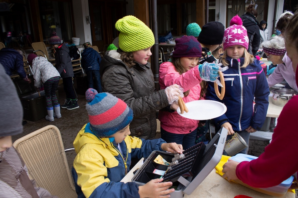 Suppe schöpfen, Würste ausgeben und Kasse machen – die drei Posten der Kinder an den Verkaufstischen.