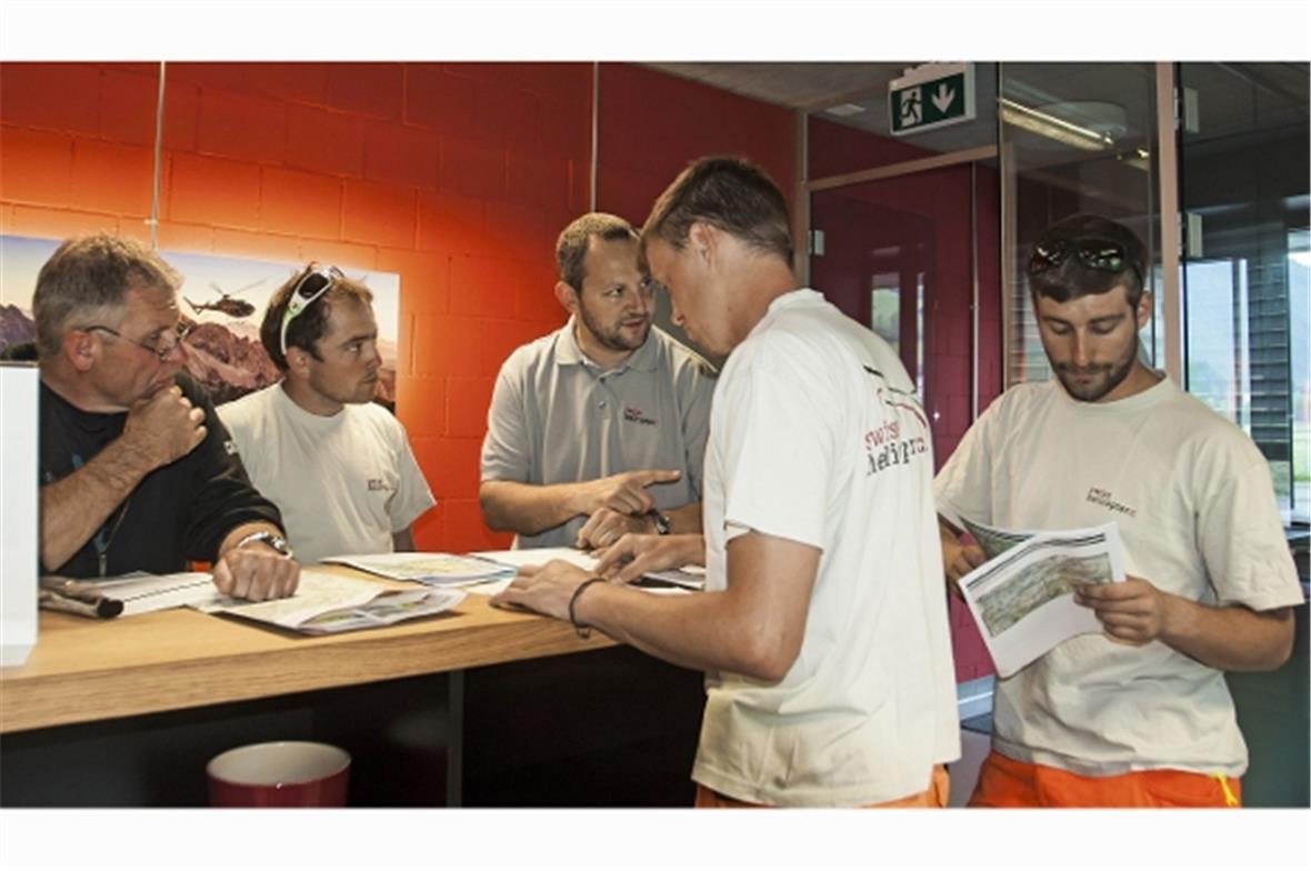 Team-Besprechung vor dem Abflug. Patrick Aegerter geht zusammen mit seinem Team die Einzelheiten der anstehenden Transportflüge durch. Pilot Martin Nüssli, Chef-Flugbegleiter Koni Trachsel, Basisleiter Patrick Aegerter, Flughelfer mit Tankfahrzeug Manuel Rufener und Flugbegleiter David Sahli.