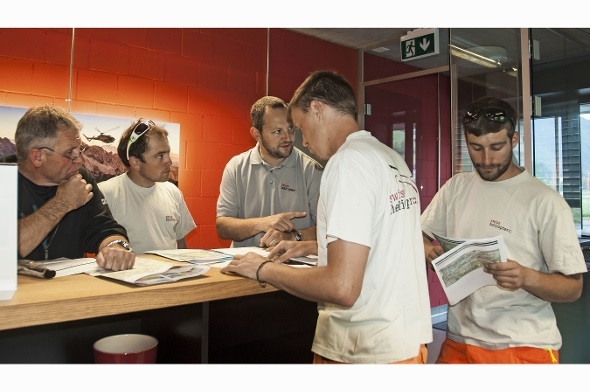Team-Besprechung vor dem Abflug. Patrick Aegerter geht zusammen mit seinem Team die Einzelheiten der anstehenden Transportflüge durch. Pilot Martin Nüssli, Chef-Flugbegleiter Koni Trachsel, Basisleiter Patrick Aegerter, Flughelfer mit Tankfahrzeug Manuel Rufener und Flugbegleiter David Sahli.