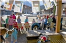 Verkauf auf dem sonnigen Kronenplatz: Die KäuferInnen stehen beim Buchstaben ihr...