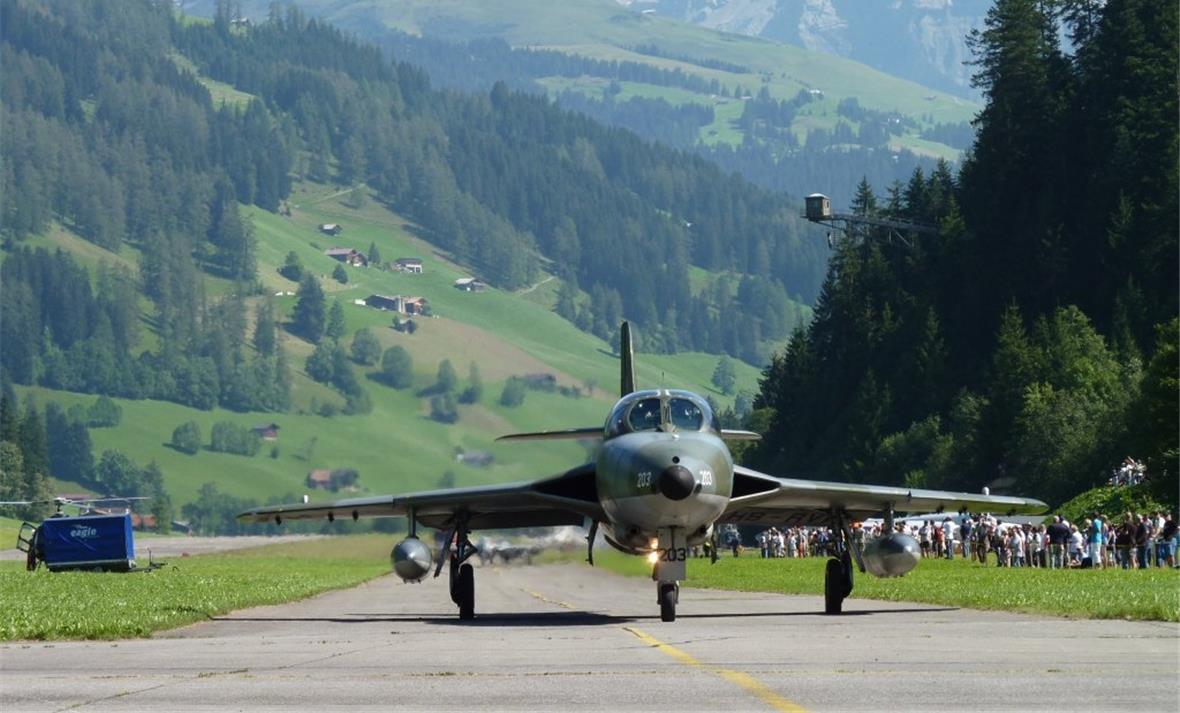 Vor der eindrücklichen Bergkulisse rollt ein Hunter zur Startbahn.