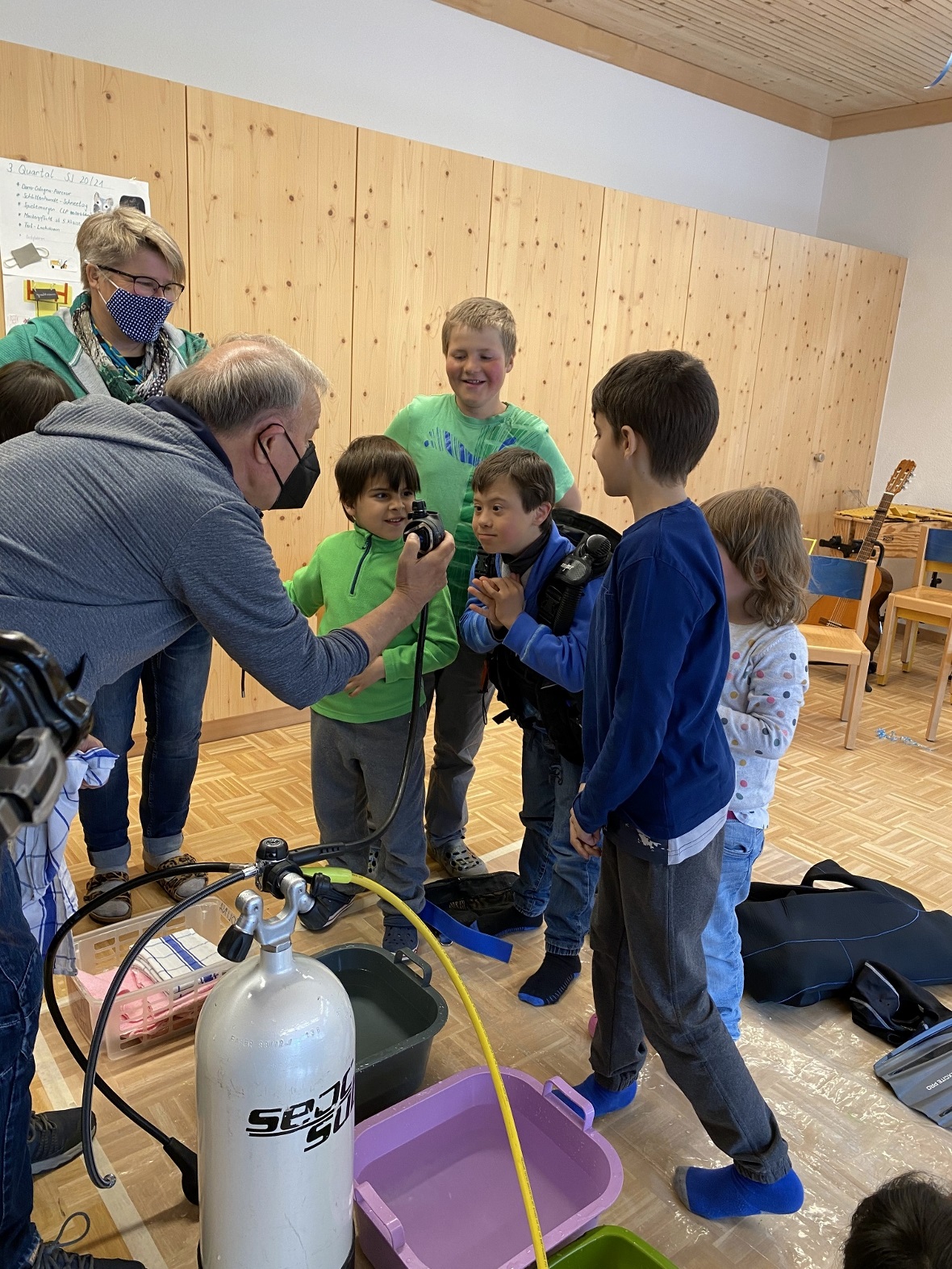 Was ist da drin? – interessiert lassen sich die Kinder das Taucherequipment erkl...