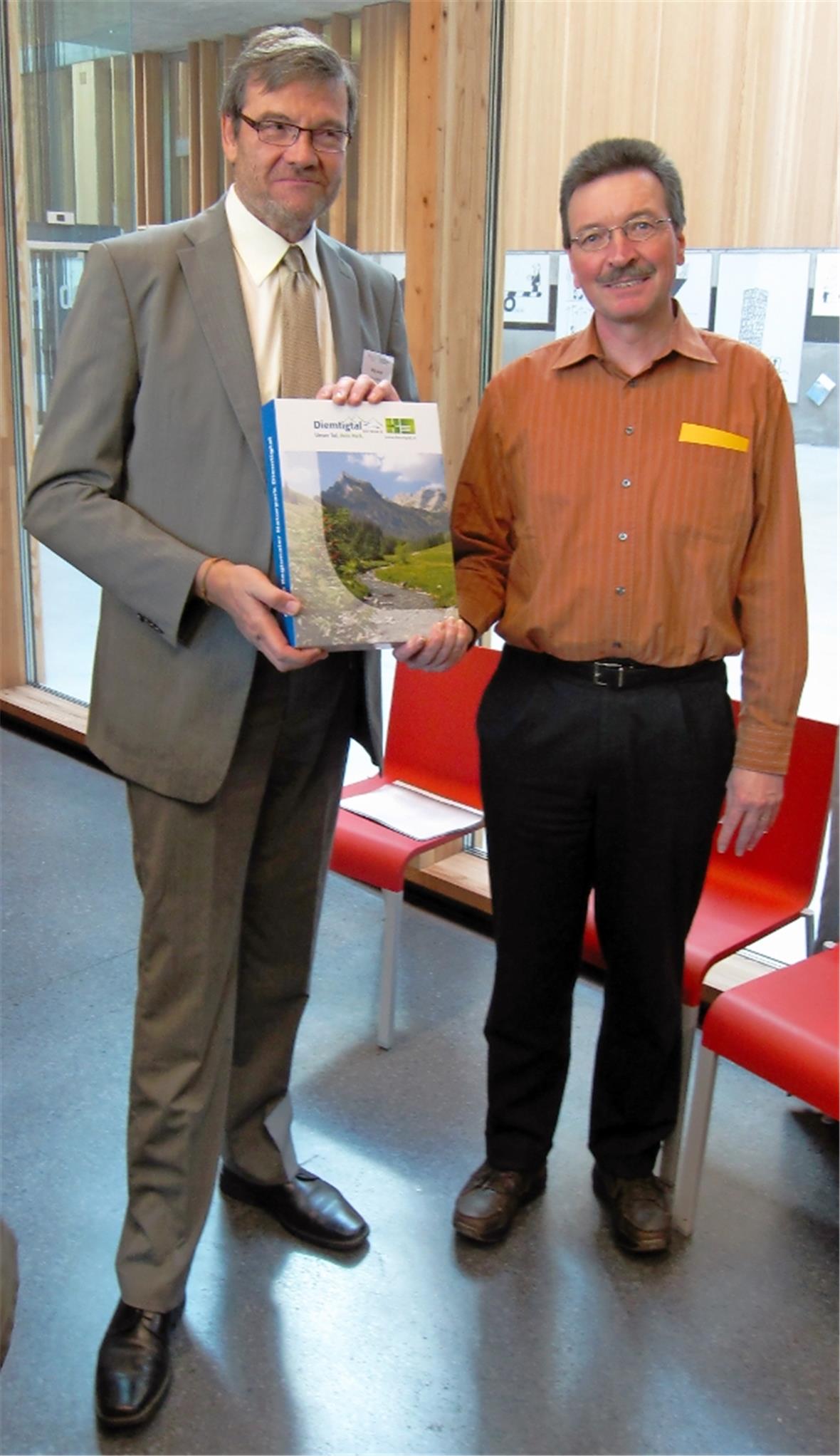 Willi Geiger, Vizedirektor des BAFU, nimmt von Markus Mösching, Präsident der Naturparkkommission Diemtigtal das umfangreiche Dossier entgegen.