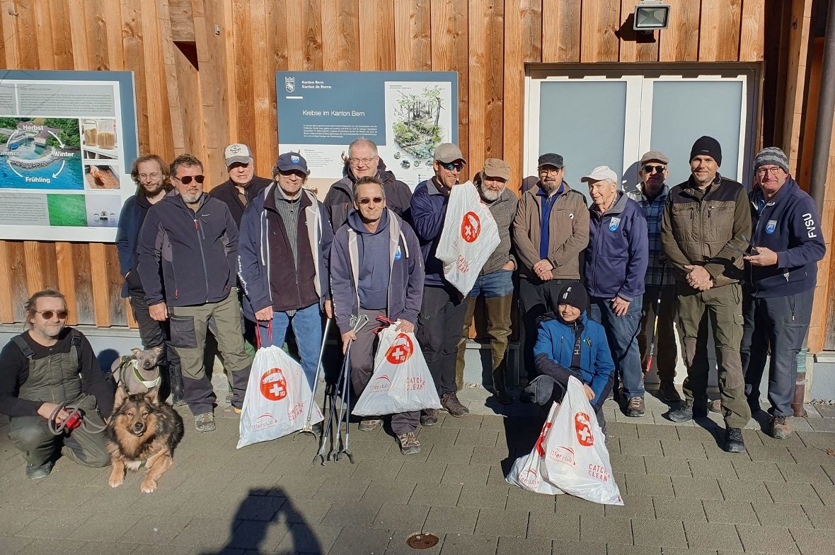 Zufriedene, lächelnde Fischerinnen und Fischer mit Catch & Clean-Kehrichtsäcken.