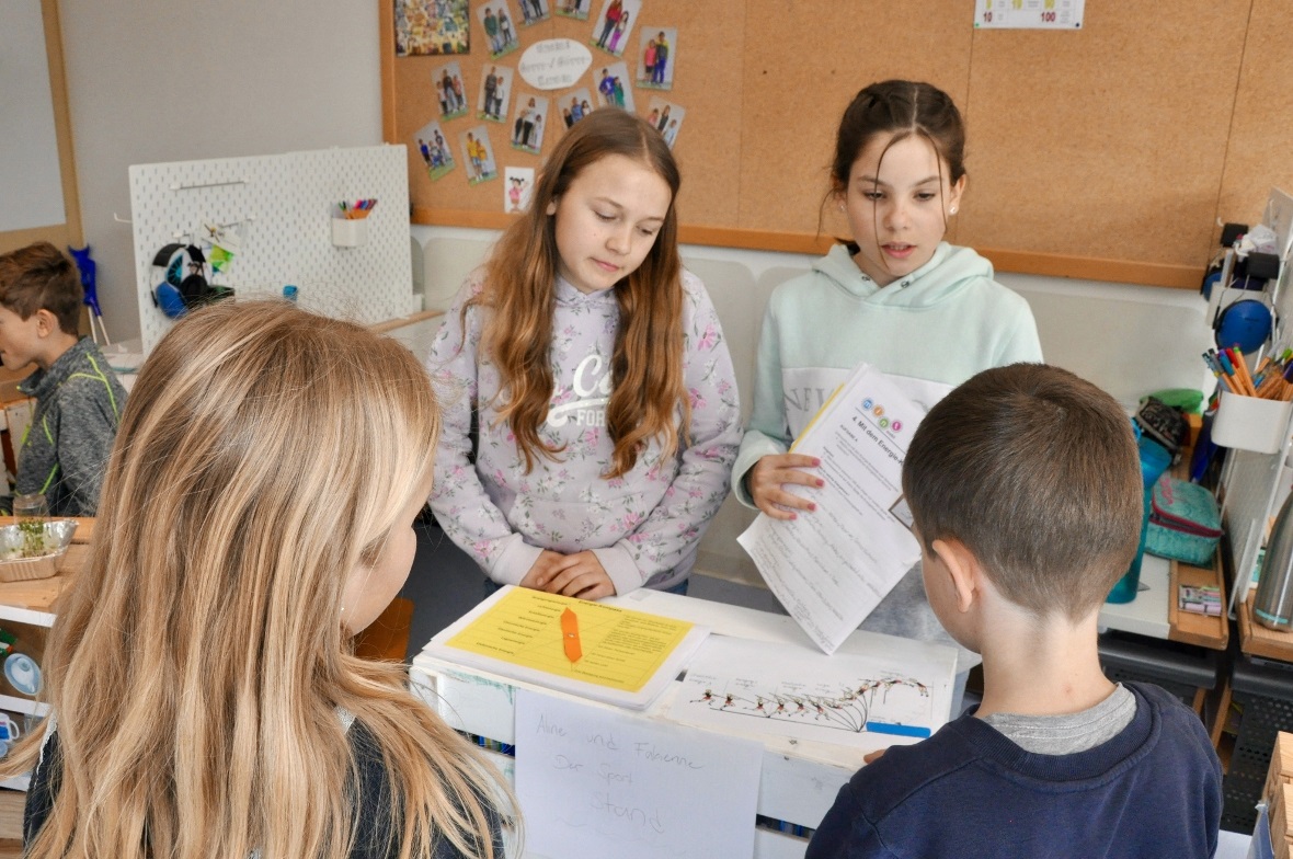 Zwei Schülerinnen der 5./6. Klasse erklären SuS der 3./4. Klasse welche Energief...